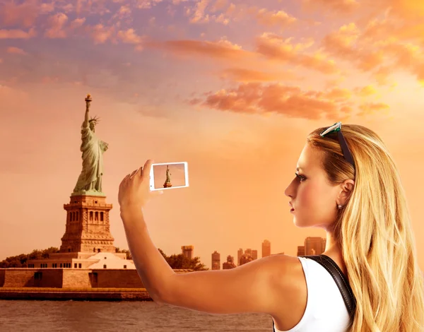 Blond toeristische nemen foto naar standbeeld van Liberty Nyc — Stockfoto