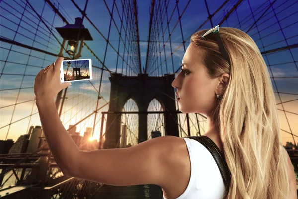 Blond toeristische meisje nemen foto in Brooklyn Bridge — Stockfoto