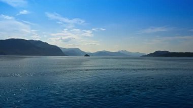 Batı Norveç 'teki Langfjorden ve Midfjorden fiyortları sakin mavi su ve dağ manzarası gösteriyor.