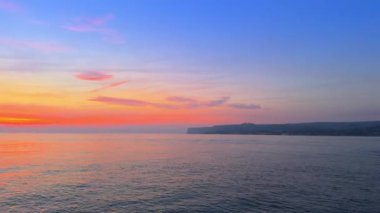 San Antonio Burnu üzerinde Denia gün doğumu, sakin deniz, renkli gökyüzü, deniz feneri ve tekne Costa Blanca 'da, Marina Alta