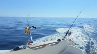 Balıkçı teknesindeki oltaları, açık deniz dalgalarını ve berrak gökyüzünün altındaki mavi suları avlıyoruz.