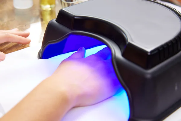 Nagellackierung mit UV-Trockenlampe im blauen Licht — Stockfoto