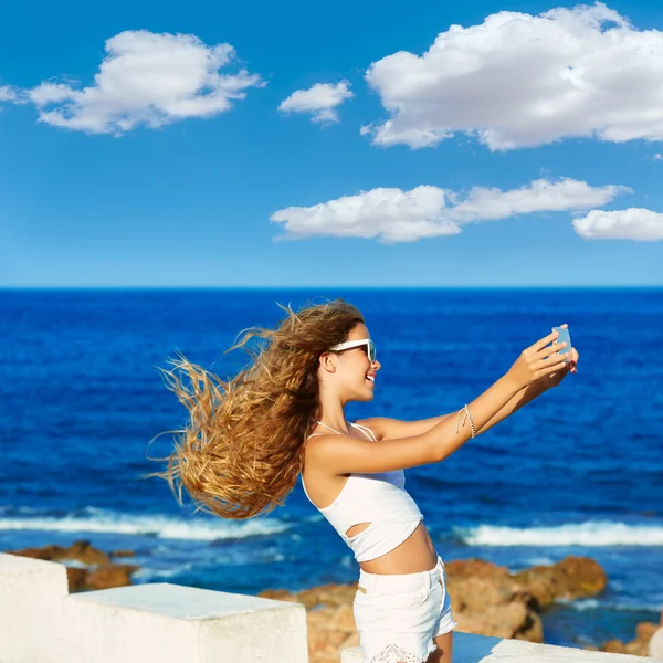 Blonde tiener meisje foto selfie op smartphone op strand — Stockfoto