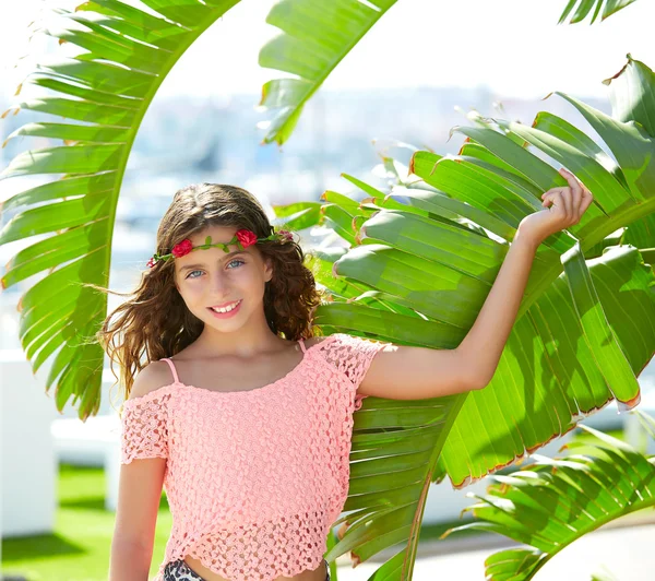 Brunette kid girl at banana tree leaves in bright day — Stock Photo, Image