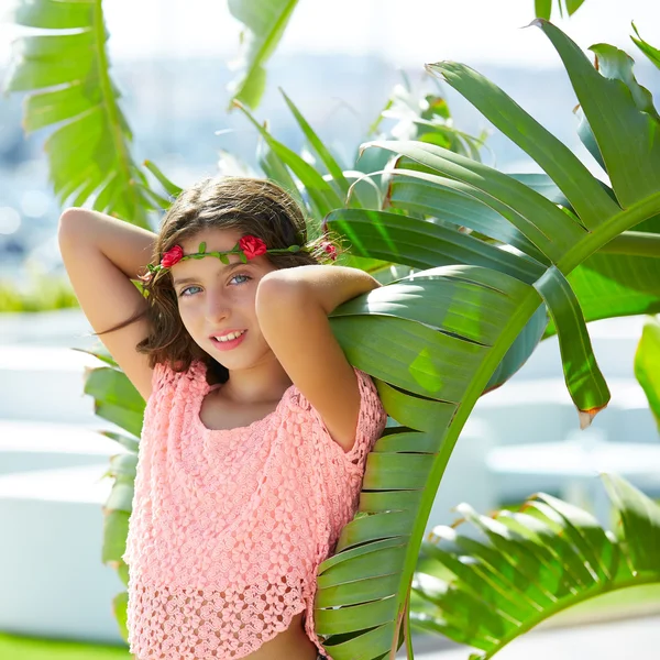 Brunette kid girl at banana tree leaves in bright day — Stock Photo, Image