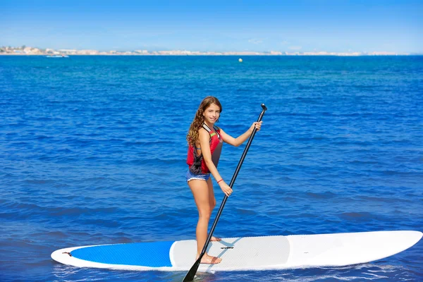 Kid paddle surf surfer meisje met rij in het strand — Stockfoto