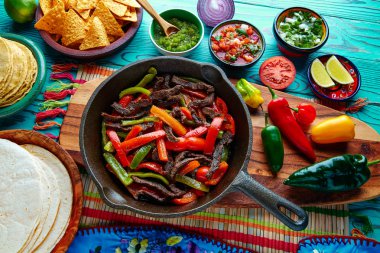 Bir tavada sığır eti fajitas acılı sosları ve Meksika taraf