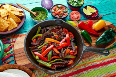 Bir tavada sığır eti fajitas acılı sosları ve Meksika taraf