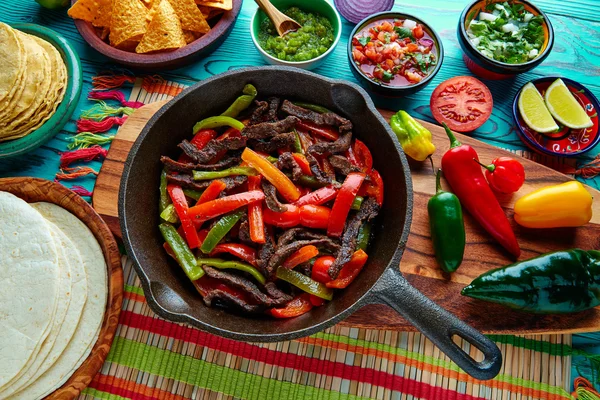 Fajitas de carne de vaca em uma panela molhos chili e lados mexicano — Fotografia de Stock