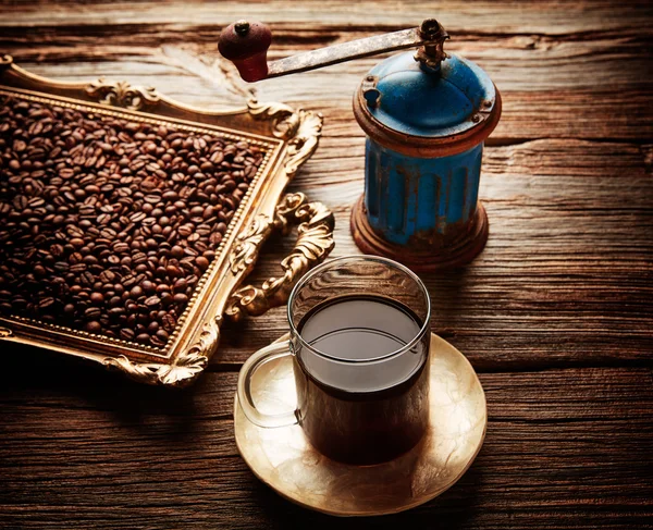 Šálek kávy s vintage bruska na dřevo stůl — Stock fotografie