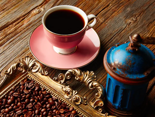 Koffiekopje met vintage grinder op houten tafel — Stockfoto