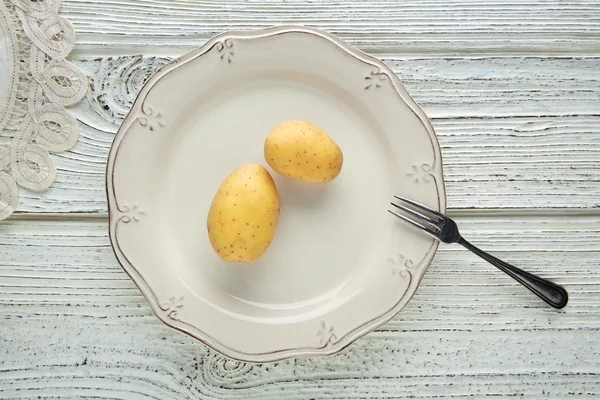 Potatoes in white plate minimalist food concept — Stock Photo, Image