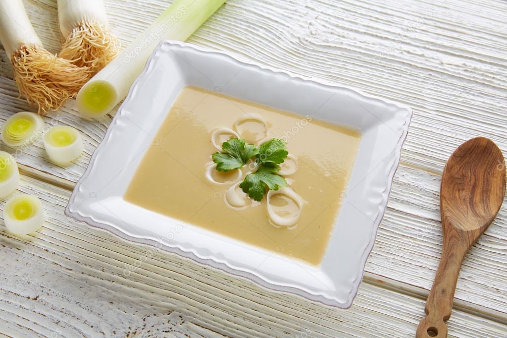 vichyssoise cream soup with leeks on white wood