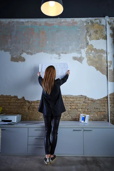 Architect bedrijf plan op muur volledige lengte achteraanzicht — Stockfoto