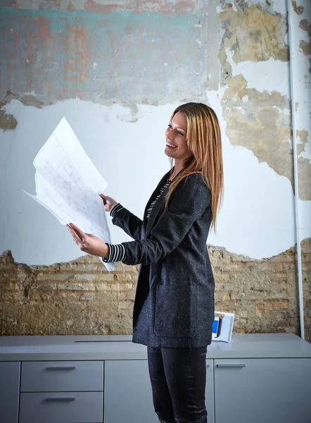 Архитектор женщина работает план холдинга в офисе — стоковое фото