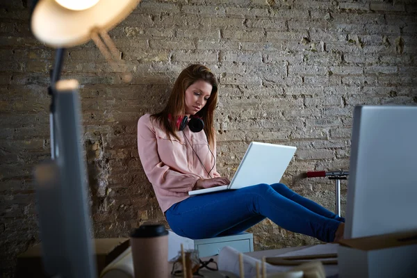 Ділова жінка випадково сидить в офісі з ноутбуком — стокове фото