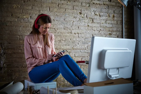 Mobiele muziek hoofdtelefoon van de hoorzitting van de vrouw op kantoor — Stockfoto