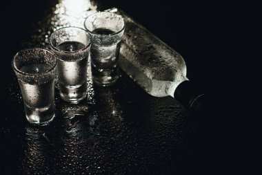 Siyah arka planda shot bardaklı soğuk votka. Üst Manzara. Gıda arkaplanı