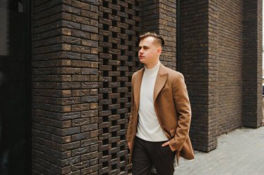 Zarif takım elbiseli yakışıklı bir iş adamının portresi. Sokakta poz veren bir adam. Metroseksüel