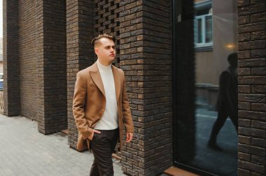 Zarif takım elbiseli yakışıklı bir iş adamının portresi. Sokakta poz veren bir adam. Metroseksüel