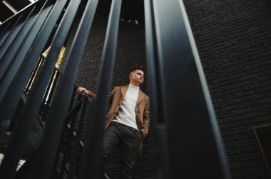 Palto giymiş, açık havada sakallı şık bir adamın portresi.