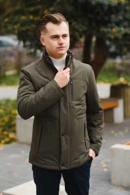 Palto giymiş, açık havada sakallı şık bir adamın portresi.