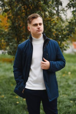 Palto giymiş, açık havada sakallı şık bir adamın portresi.