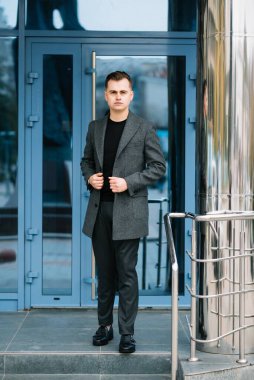 Palto giymiş, açık havada sakallı şık bir adamın portresi.