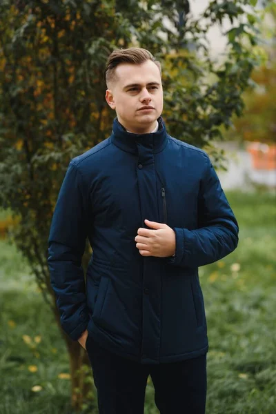 Palto giymiş, açık havada sakallı şık bir adamın portresi.