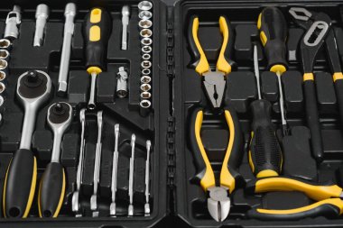 Sarı ve siyah kullanışlı araçlar (sütunlar ve tornavidalar) sarı arkaplanda izole