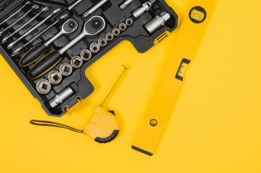 Çeşitli inşaat aletleri. Ev onarımı için aletler. İnşaat alanında çalışıyorum. Sarı arka planda. Dümdüz. Düz Yatay.