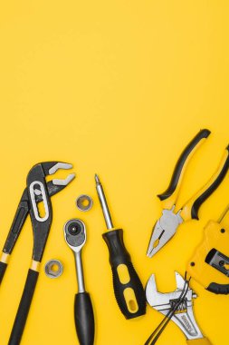 Sarı ve siyah kullanışlı araçlar (sütunlar ve tornavidalar) sarı arkaplanda izole
