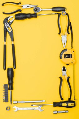 Sarı arkaplanda araç üst görünümü. Kerpeten, anahtarı aç, tornavida ve zımba tabancası düz ve kopyalama alanı var..