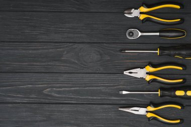 Koyu ahşap arka planda, kopyalama alanı olan çeşitli marangozluk ve çilingir araçları.