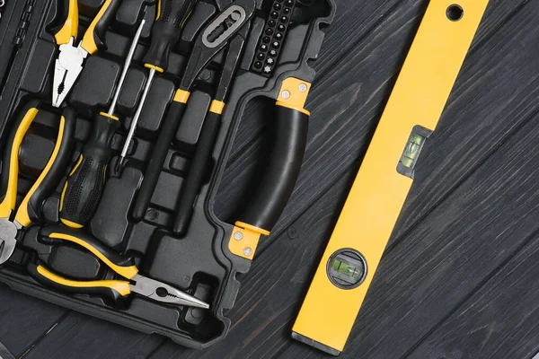 Ahşap dokuya sahip yeni kare siyah alet kutusu. Üst görünüm