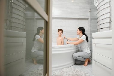 Anne oğlunu banyoda yıkıyor.