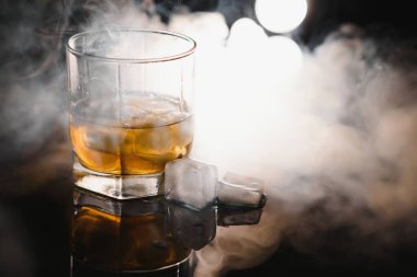 Buzlu viski, siyah arka planda dumanlı.