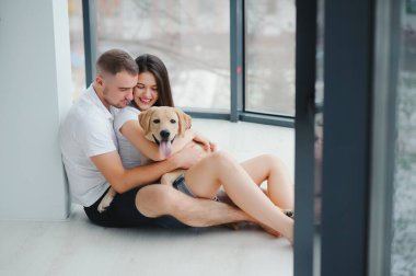 Genç ve güzel bir çift yeni evlerinde yerde oturuyor..