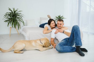 Genç ve güzel bir çift yeni evlerinde yerde oturuyor..