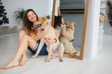 Evde köpeğiyle mutlu bir kadının portresi.