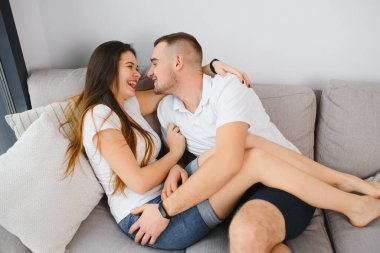 Birbirini seven iki insanın yatakta otururken kucaklaşması.