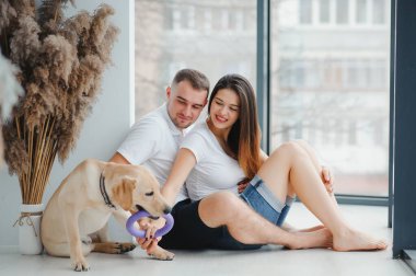 Guy ve kız arkadaşı yatak odasında dinleniyorlar. Mutlu çift evcil hayvanlarına bakar kim oynamak ister