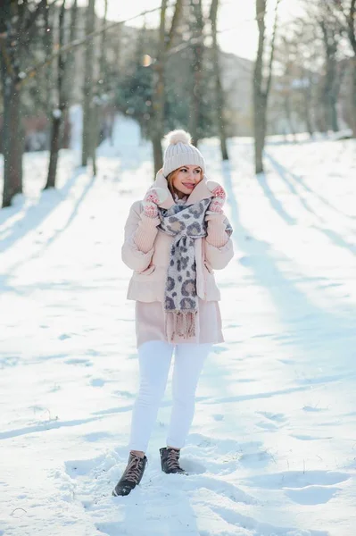 Beautiful winter portrait of young woman in the winter snowy scenery