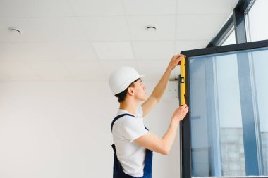 İnşaat işçisi eve pencere kuruyor