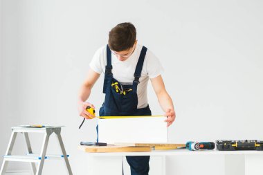 Onarım, inşaat ve inşaat kavramı - arka plandaki yeni evde mutlu gülümseyen erkek işçi ya da gözlüklü müteahhit