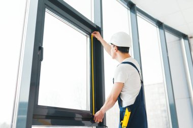 İnşaat işçisi eve pencere kuruyor