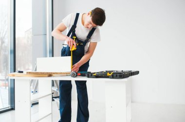 Onarım, inşaat ve inşaat kavramı - arka plandaki yeni evde mutlu gülümseyen erkek işçi ya da gözlüklü müteahhit