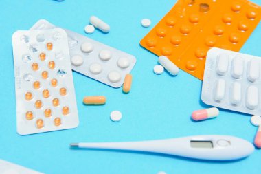 İlaçlar ve hap paketleri, yakın plan. Metninizi yerleştireceğiniz yer, mavi arkaplan. Eczacılar ve klinikler.