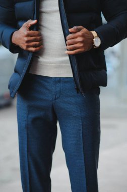 Sokakta yeni şık kıyafetler giymiş Afro-Amerikalı bir adam.