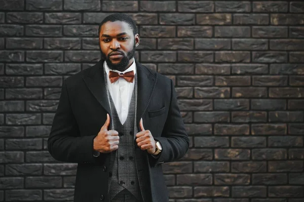 Fashion portrait of a handsome young African American business man walking outdoors in a casual pose.